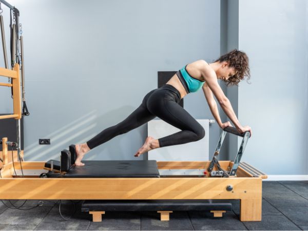 mulher praticando pilates com foco em flexibilidade no exercício em questão