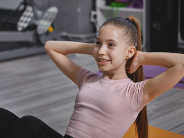 menina fazendo exercício abdominal.