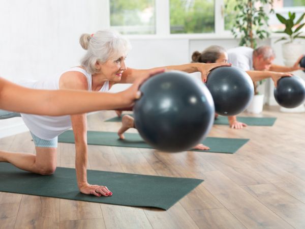 grupo de idosos praticando pilates de solo